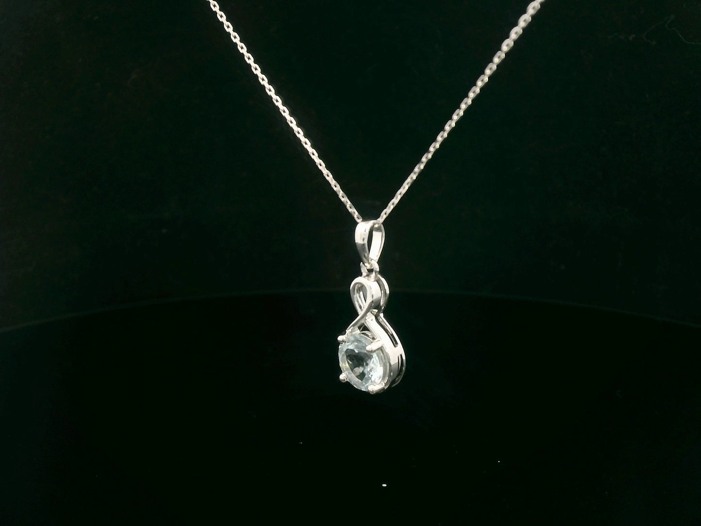 18k white gold pendant with 1.10-carat round-cut aquamarine in infinity-style bail design