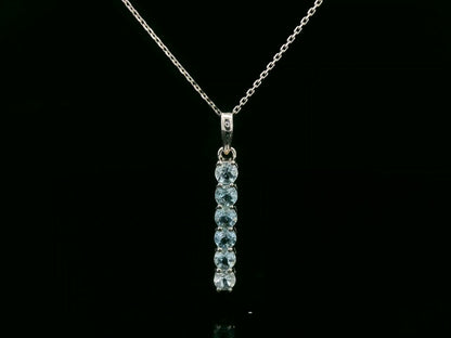 18k gold vertical bar pendant with six round-cut aquamarines totaling 0.72 carat