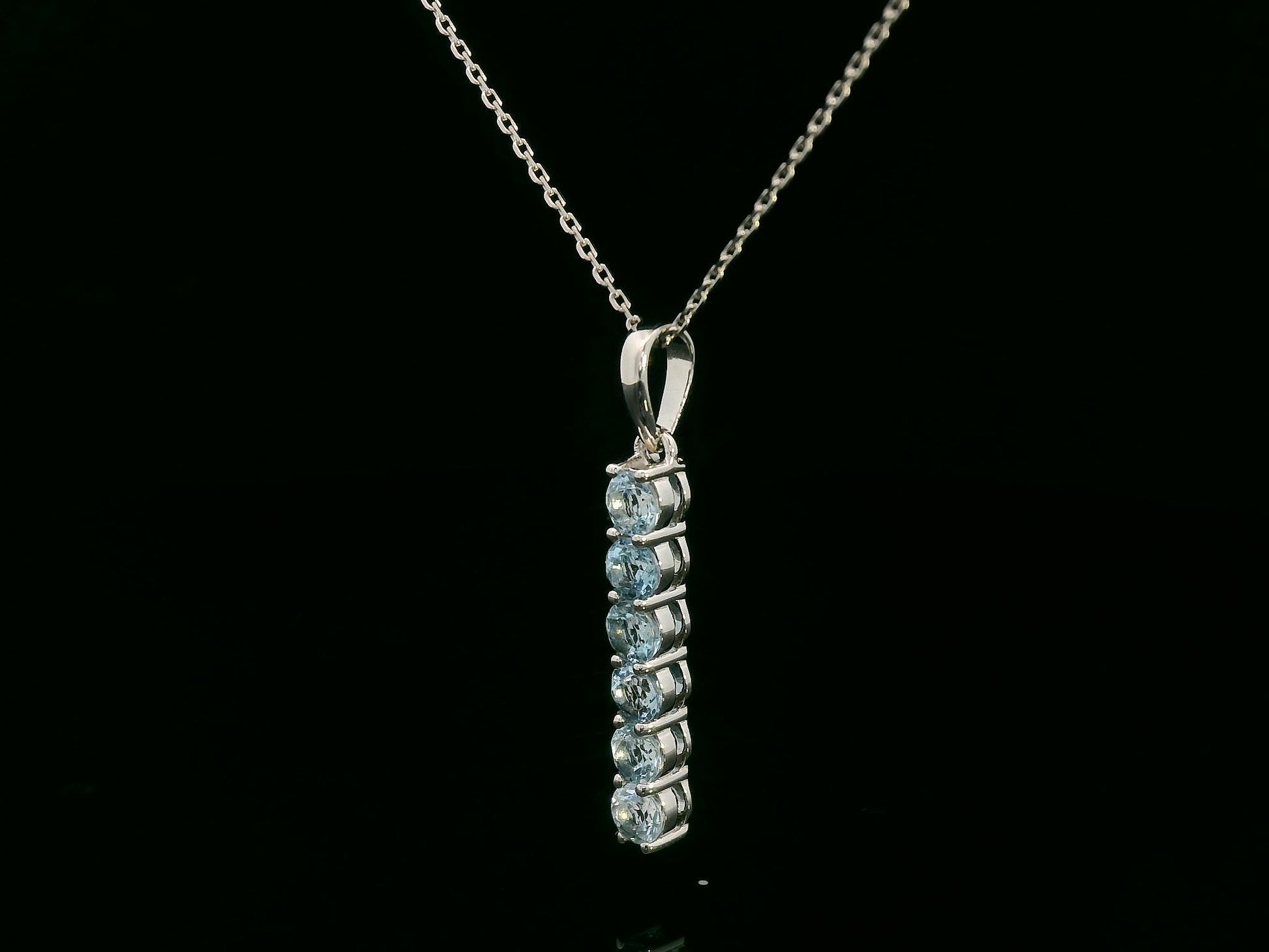18k gold vertical bar pendant with six round-cut aquamarines totaling 0.72 carat