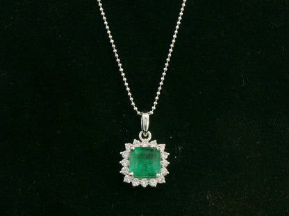 18K white gold emerald and diamond halo pendant by Emirates Diamonds
