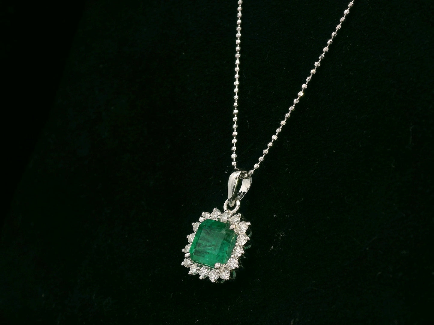 18K white gold emerald and diamond halo pendant by Emirates Diamonds