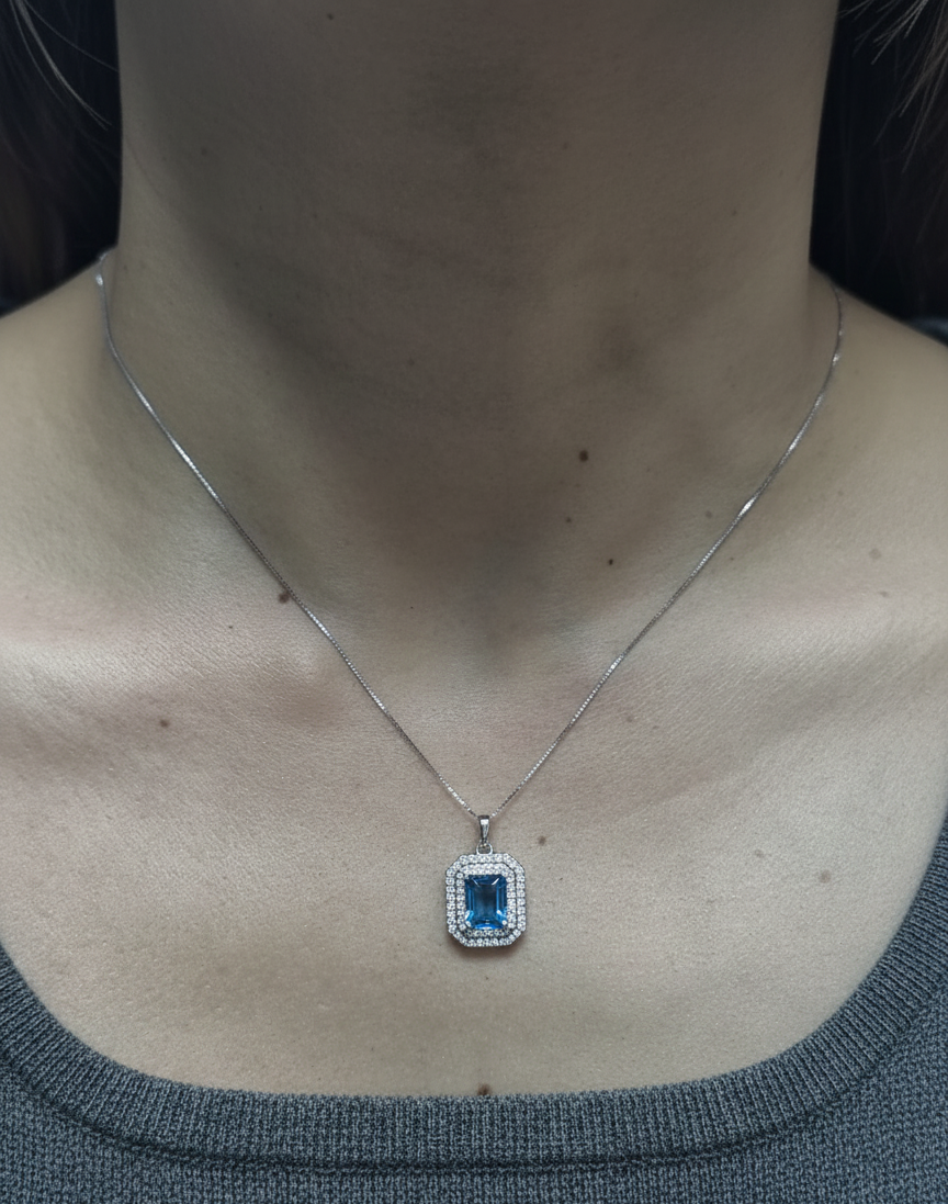 18K white gold Swiss blue topaz and diamond halo pendant with emerald-cut center stone – Emirates Diamonds