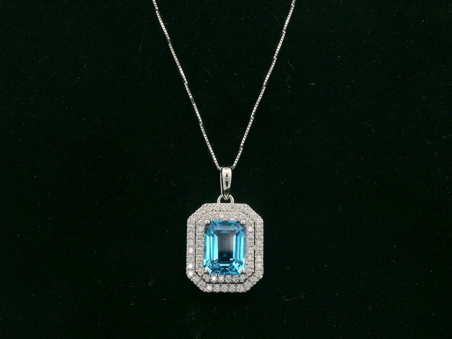 18K white gold Swiss blue topaz and diamond halo pendant with emerald-cut center stone – Emirates Diamonds