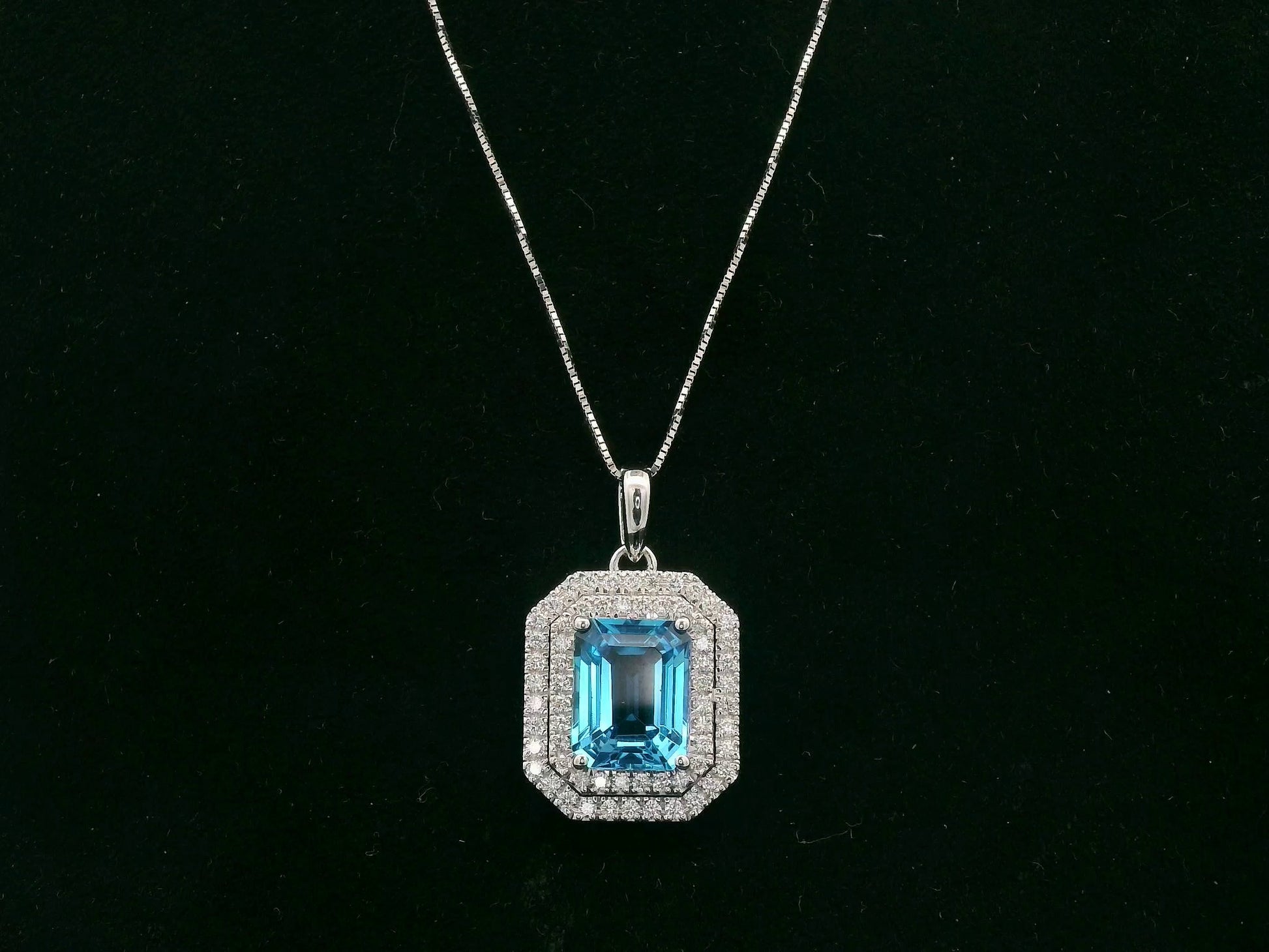 18K white gold Swiss blue topaz and diamond halo pendant with emerald-cut center stone – Emirates Diamonds