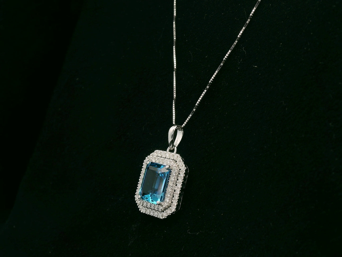18K white gold Swiss blue topaz and diamond halo pendant with emerald-cut center stone – Emirates Diamonds