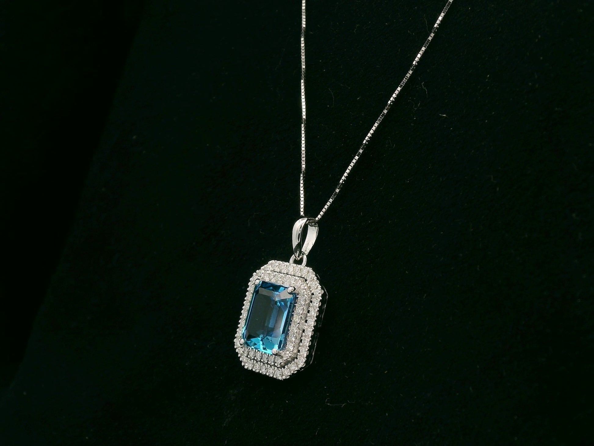 18K white gold Swiss blue topaz and diamond halo pendant with emerald-cut center stone – Emirates Diamonds