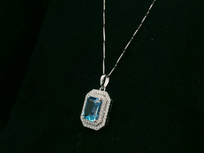18K white gold Swiss blue topaz and diamond halo pendant with emerald-cut center stone – Emirates Diamonds