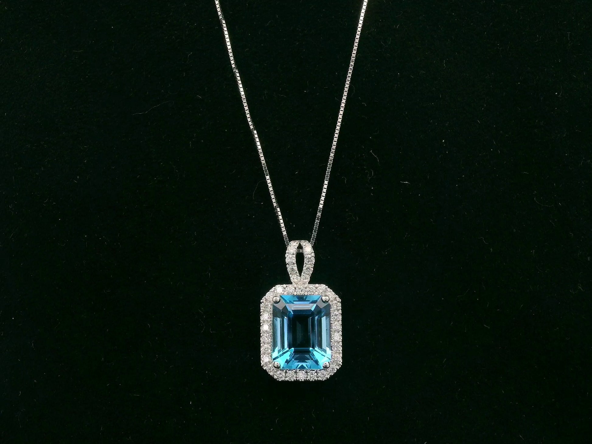 18K white gold Swiss blue topaz and diamond halo pendant necklace by Emirates Diamonds