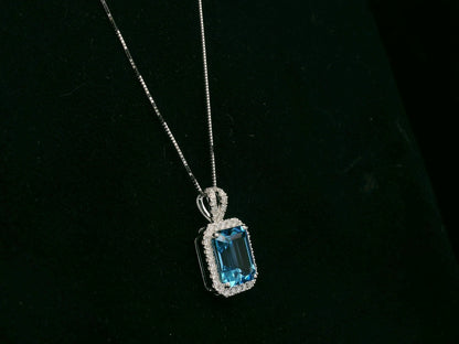 18K white gold Swiss blue topaz and diamond halo pendant necklace by Emirates Diamonds