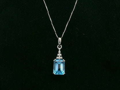 18K white gold Swiss Blue Topaz pendant with emerald-cut blue gemstone and diamond accents by Emirates Diamonds.