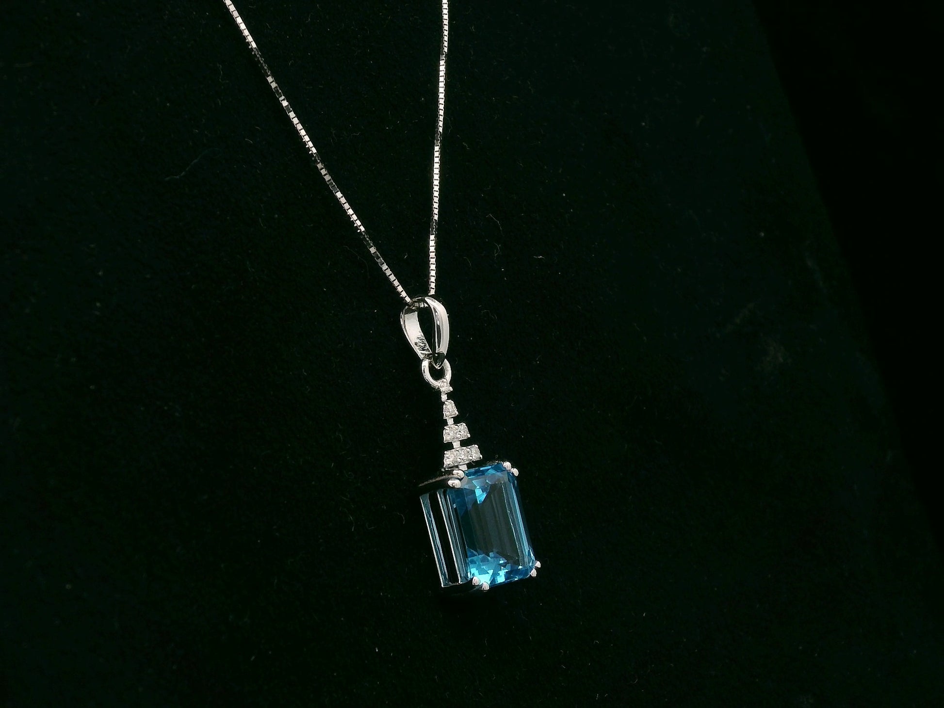 18K white gold Swiss Blue Topaz pendant with emerald-cut blue gemstone and diamond accents by Emirates Diamonds.
