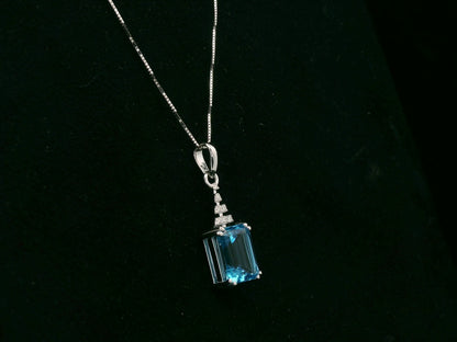 18K white gold Swiss Blue Topaz pendant with emerald-cut blue gemstone and diamond accents by Emirates Diamonds.