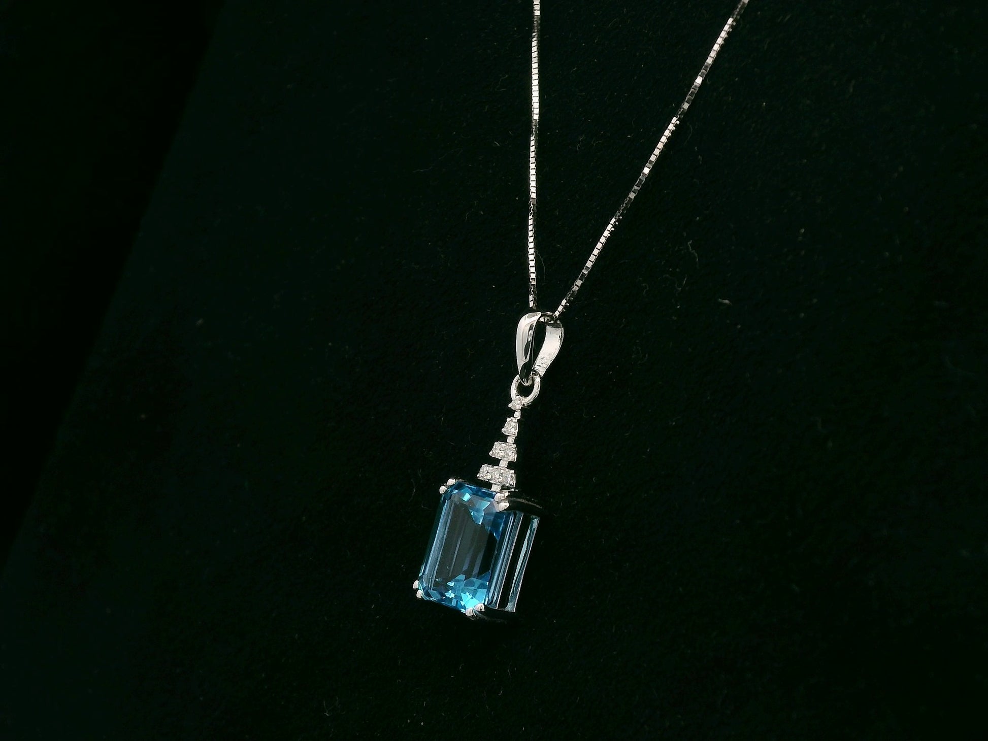 18K white gold Swiss Blue Topaz pendant with emerald-cut blue gemstone and diamond accents by Emirates Diamonds.