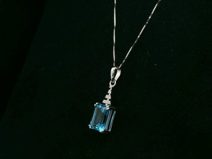 18K white gold Swiss Blue Topaz pendant with emerald-cut blue gemstone and diamond accents by Emirates Diamonds.