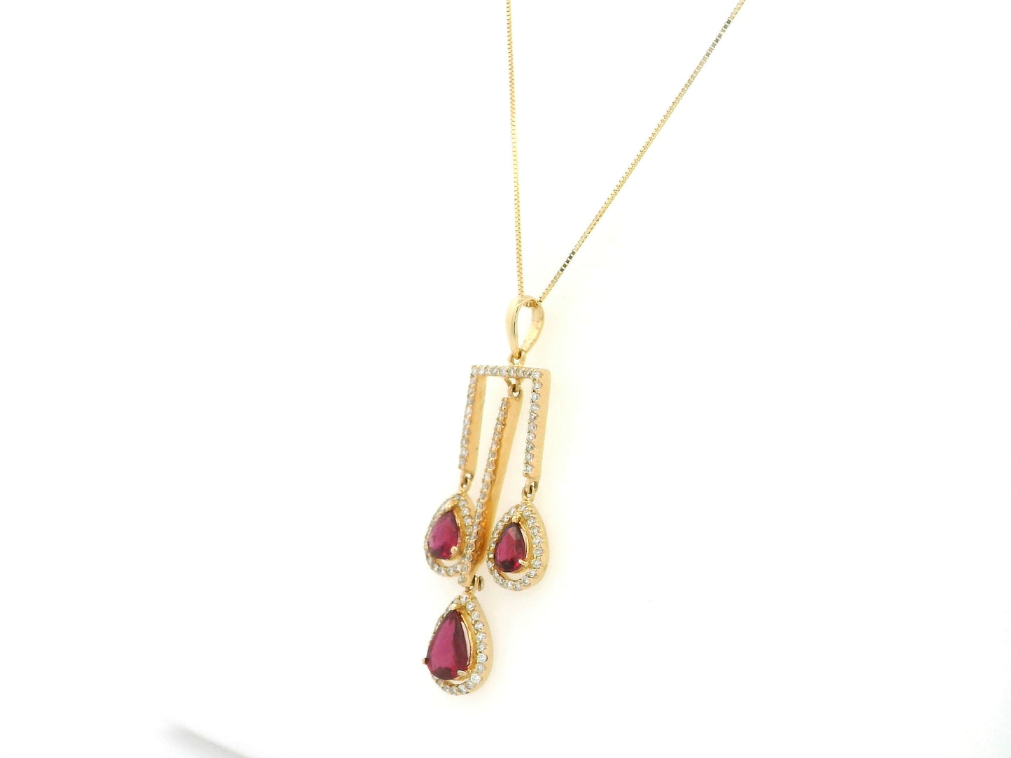 18K yellow gold ruby drop pendant with pear-cut rubies and diamond halo detailing by Emirates Diamonds