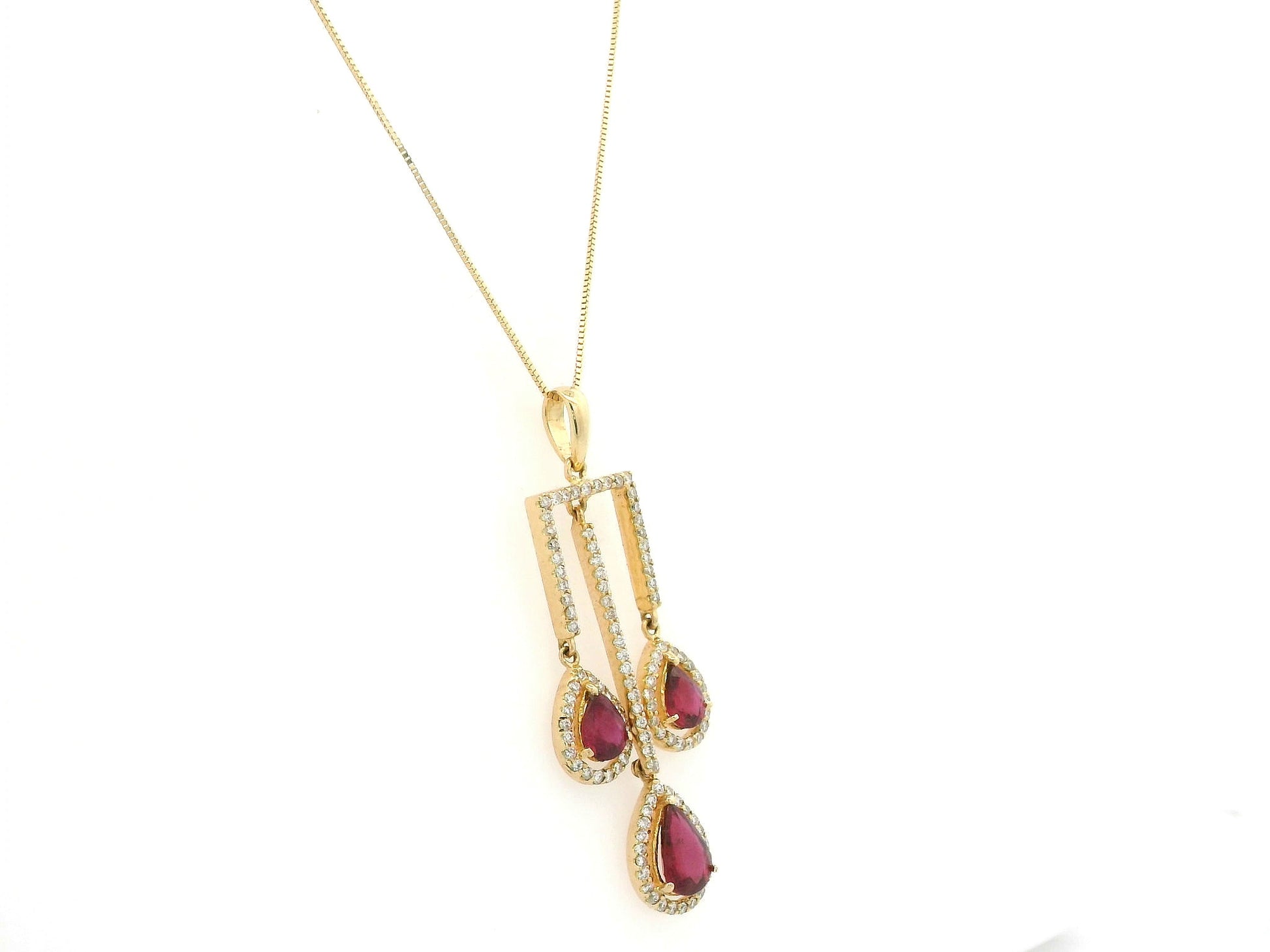 18K yellow gold ruby drop pendant with pear-cut rubies and diamond halo detailing by Emirates Diamonds