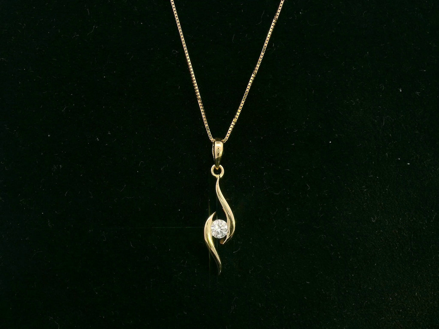 18K yellow gold diamond swirl pendant necklace featuring a 0.11 carat round diamond by Emirates Diamonds