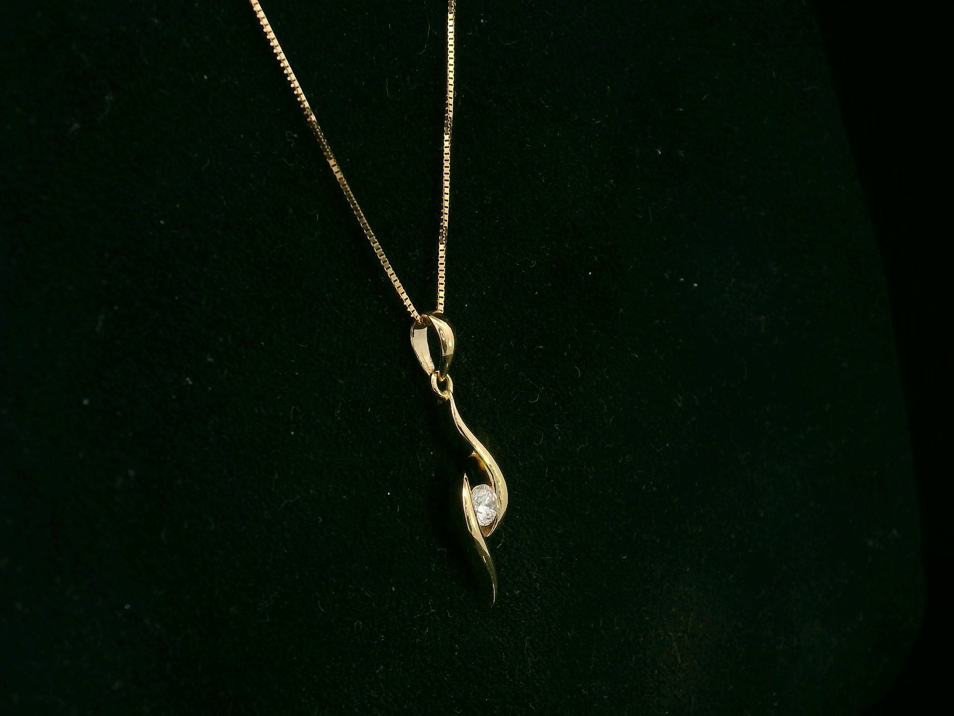 18K yellow gold diamond swirl pendant necklace featuring a 0.11 carat round diamond by Emirates Diamonds