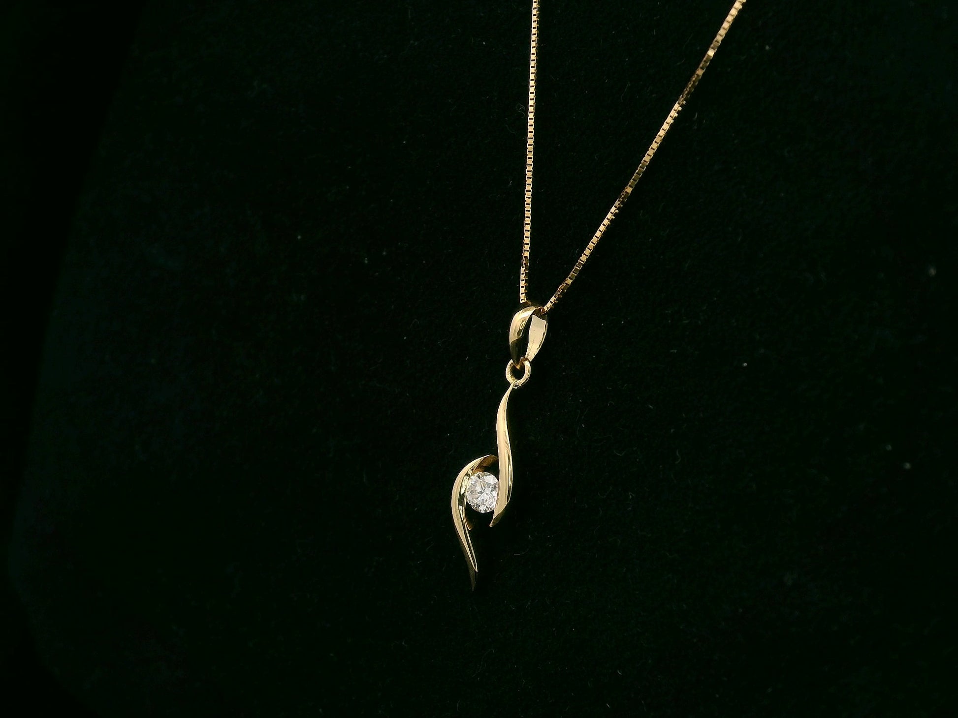 18K yellow gold diamond swirl pendant necklace featuring a 0.11 carat round diamond by Emirates Diamonds