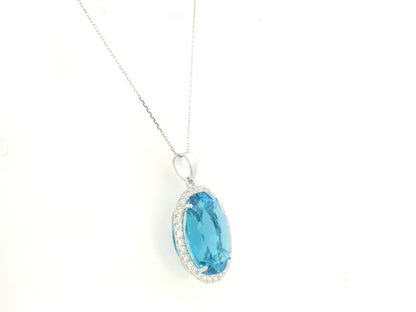 Swiss blue topaz diamond halo pendant in 18K white gold featuring a 21.51 carat oval Swiss blue topaz and 0.76 carats of diamonds by Emirates Diamonds.