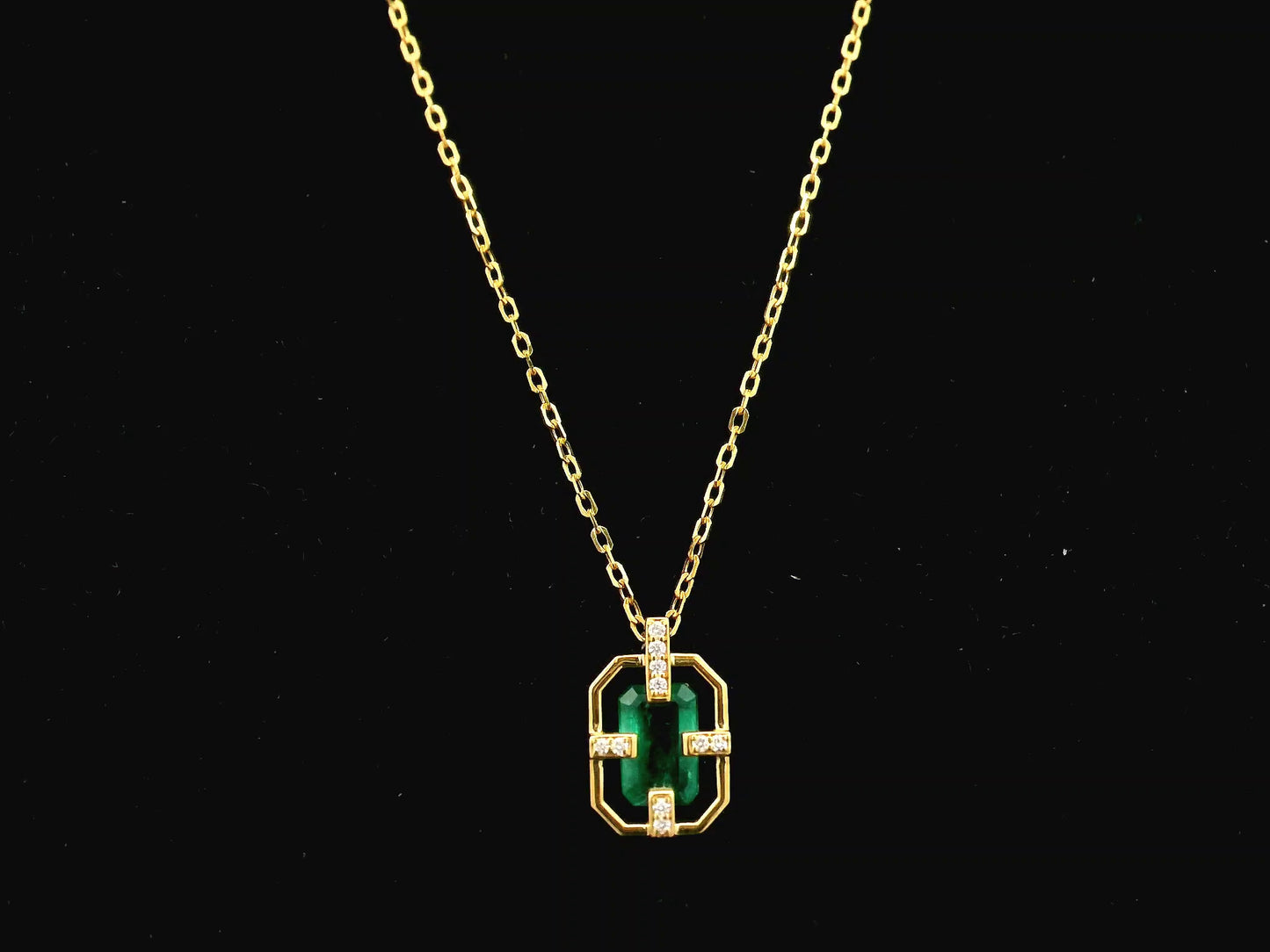 Emerald cut emerald geometric pendant necklace in 18K yellow gold with diamond accents