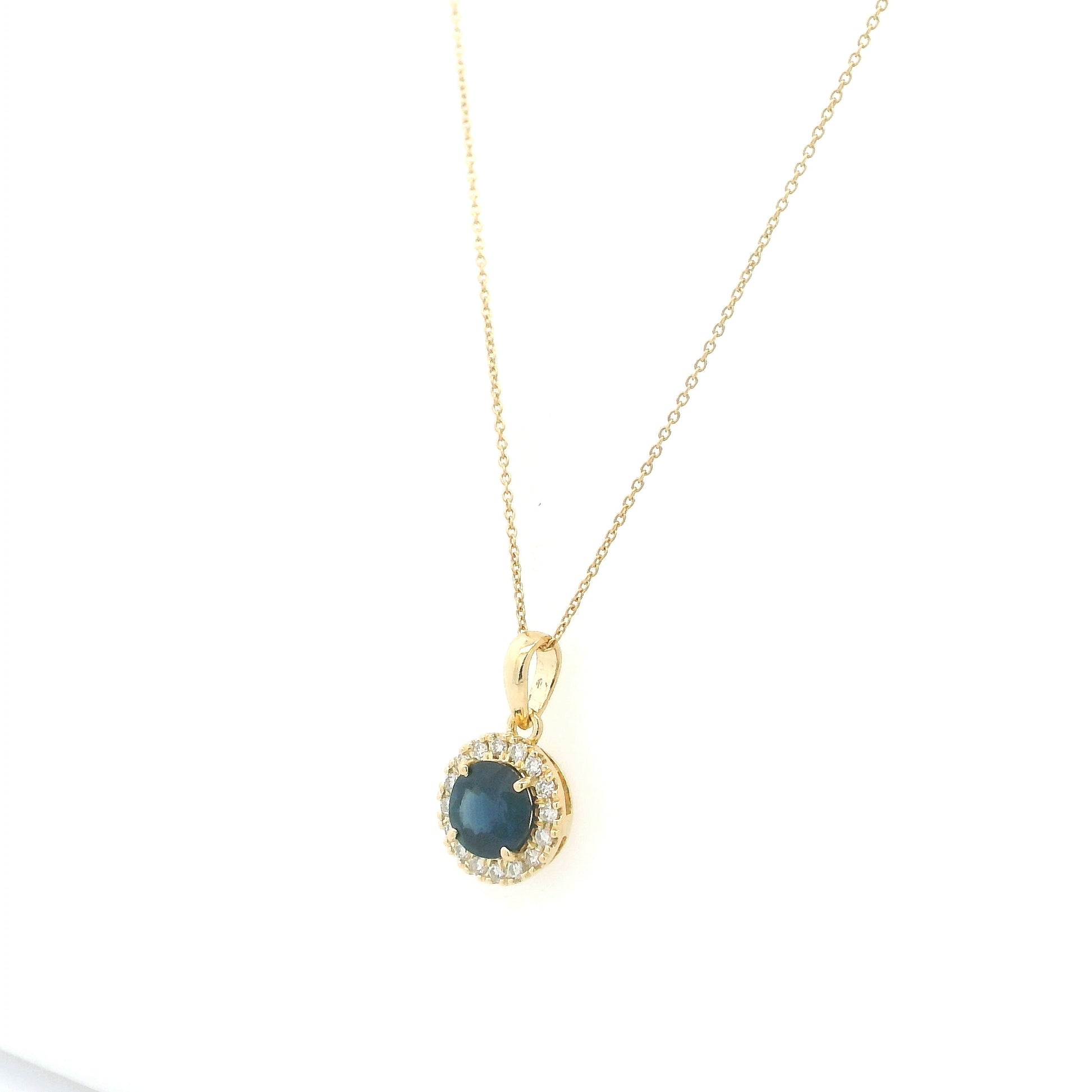 Round blue sapphire diamond halo pendant in 18K white gold.