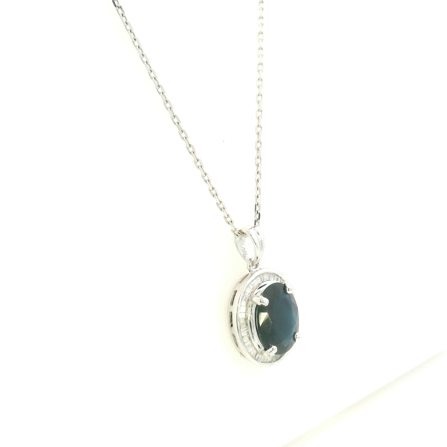 18K white gold oval blue sapphire pendant featuring a 2.71 carat natural blue sapphire surrounded by a baguette diamond halo with 0.32 carat natural diamonds. Pendant only, chain not included.