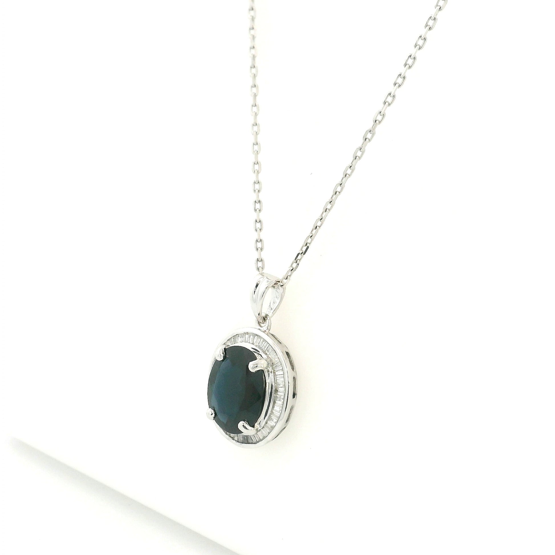 18K white gold oval blue sapphire pendant featuring a 2.71 carat natural blue sapphire surrounded by a baguette diamond halo with 0.32 carat natural diamonds. Pendant only, chain not included.
