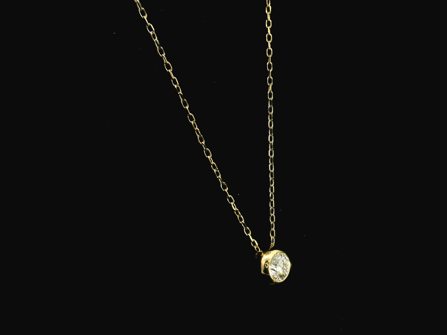 18K yellow gold diamond solitaire necklace featuring a 0.43 carat natural diamond in a modern bezel setting.