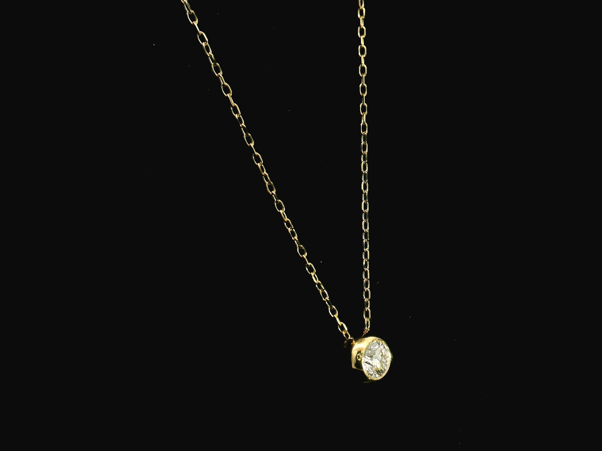 18K yellow gold diamond solitaire necklace featuring a 0.43 carat natural diamond in a modern bezel setting.