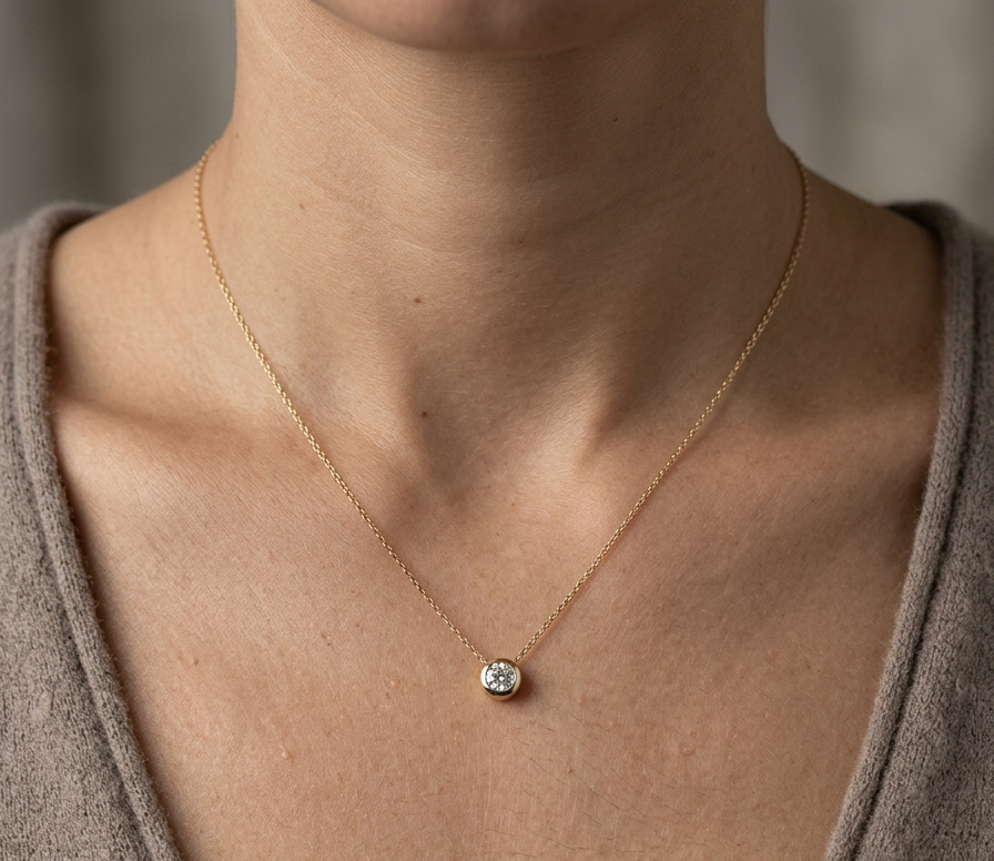 18K yellow gold diamond solitaire necklace featuring a 0.43 carat natural diamond in a modern bezel setting.