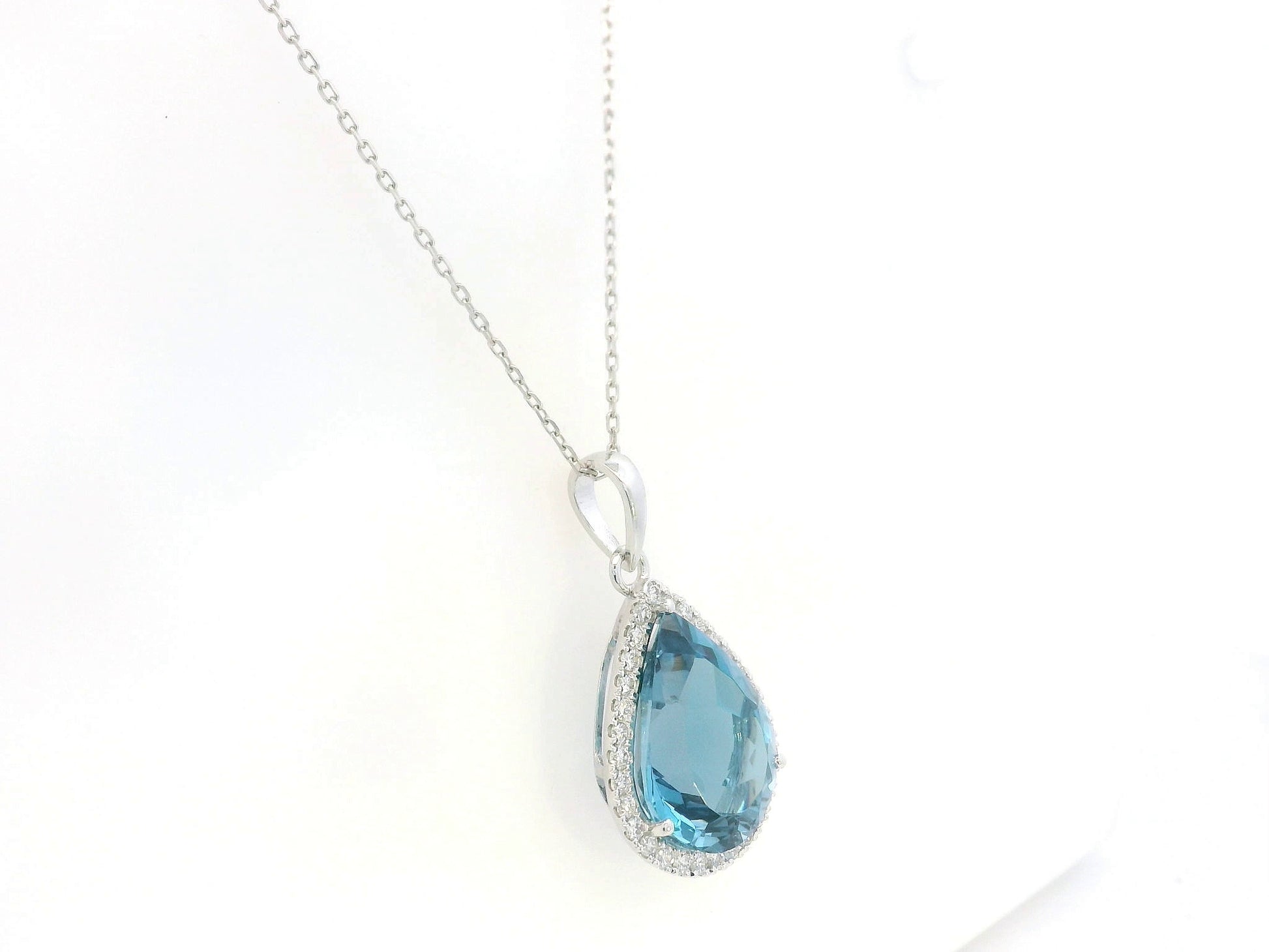 18K white gold pear shape London Blue Topaz pendant with diamond halo featuring a 9.10 carat natural London Blue Topaz and 0.39 carat natural diamonds.