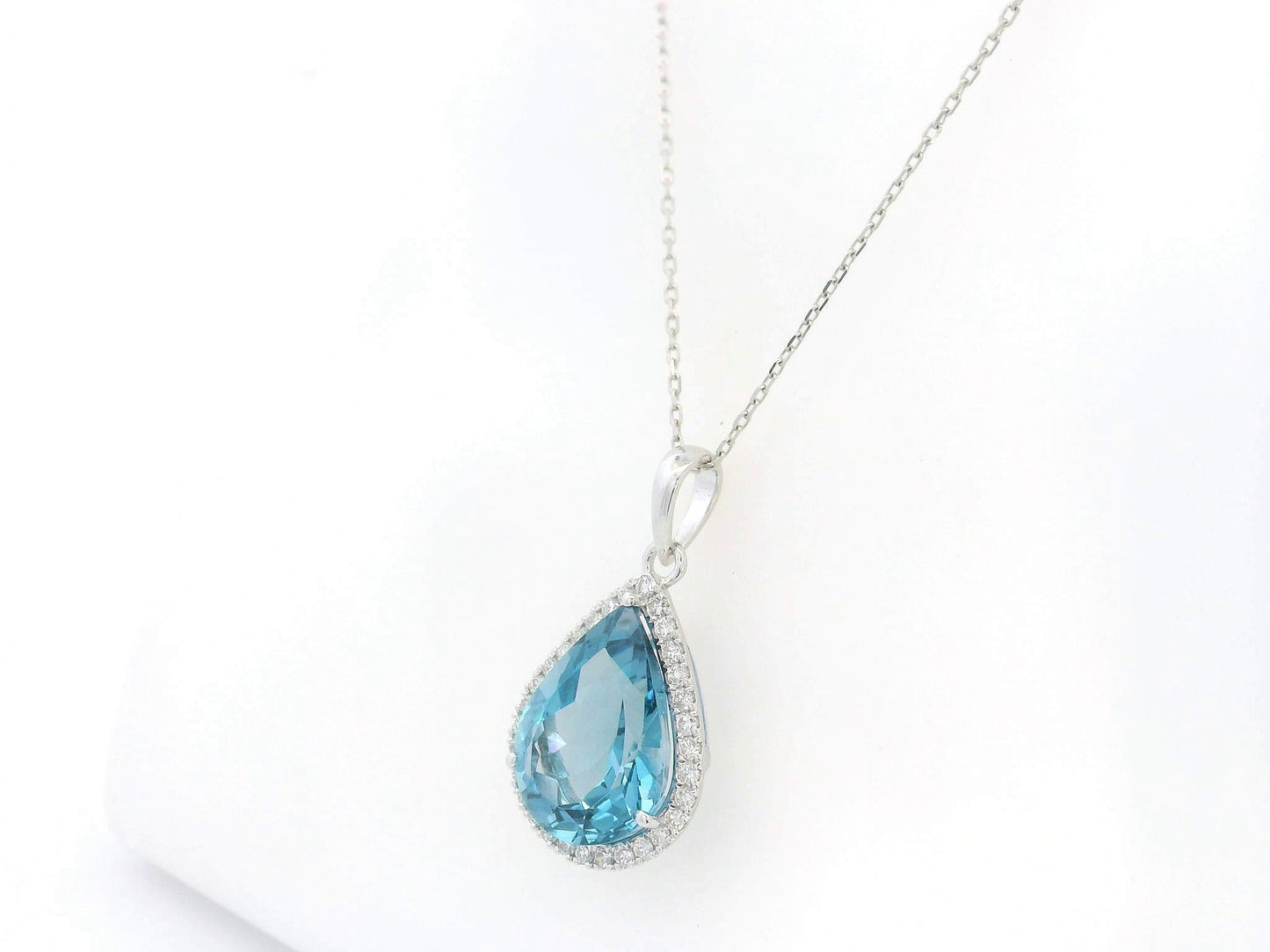 18K white gold pear shape London Blue Topaz pendant with diamond halo featuring a 9.10 carat natural London Blue Topaz and 0.39 carat natural diamonds.