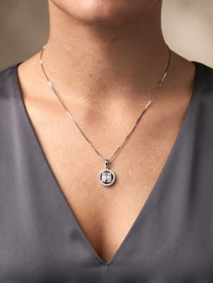 18K white gold diamond pendant featuring round and baguette natural diamonds in an emerald-cut inspired illusion cluster with a sparkling round diamond halo. Chain not included.