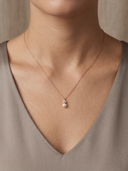 18K rose gold freshwater pearl pendant necklace featuring a white freshwater pearl suspended beneath a natural diamond cluster.