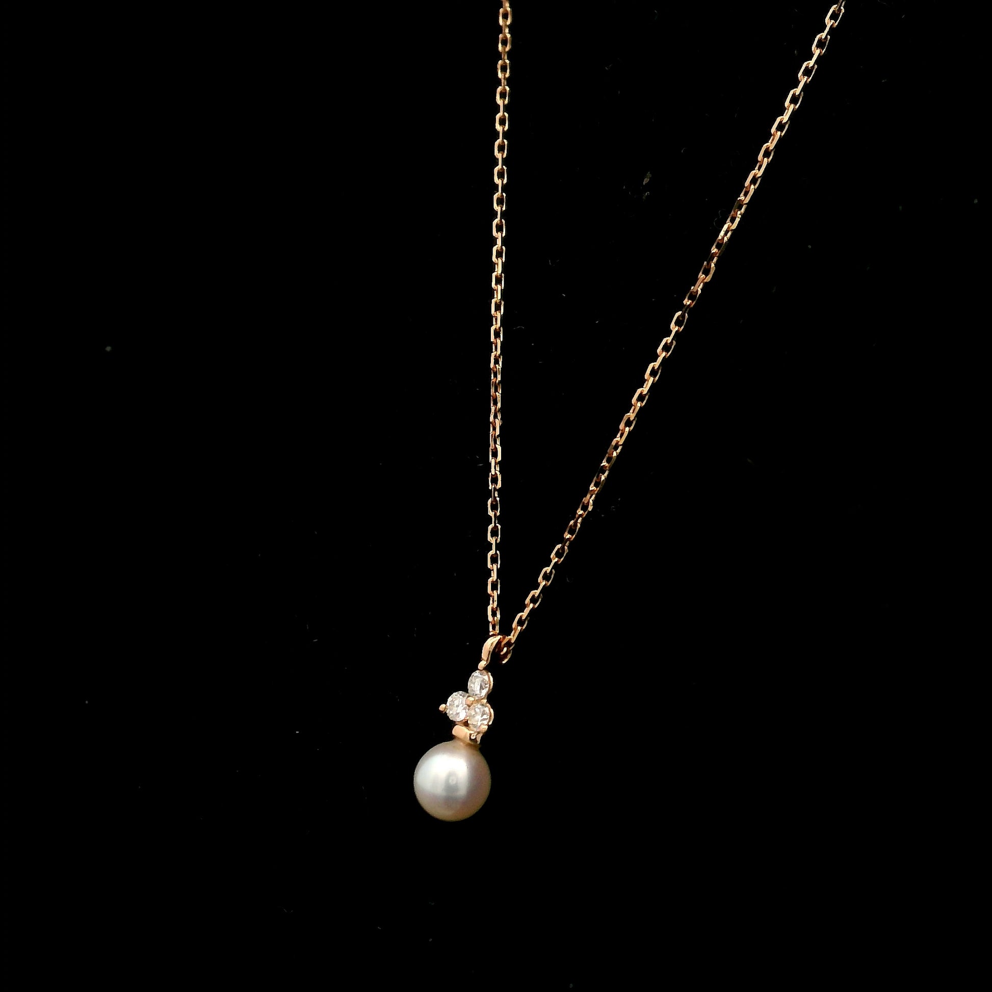18K rose gold freshwater pearl pendant necklace featuring a white freshwater pearl suspended beneath a natural diamond cluster.