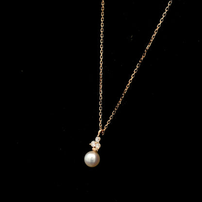 18K rose gold freshwater pearl pendant necklace featuring a white freshwater pearl suspended beneath a natural diamond cluster.
