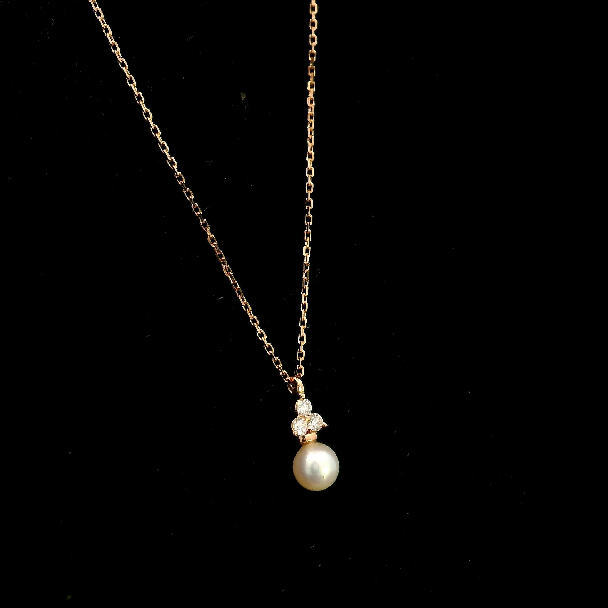 18K rose gold freshwater pearl pendant necklace featuring a white freshwater pearl suspended beneath a natural diamond cluster.