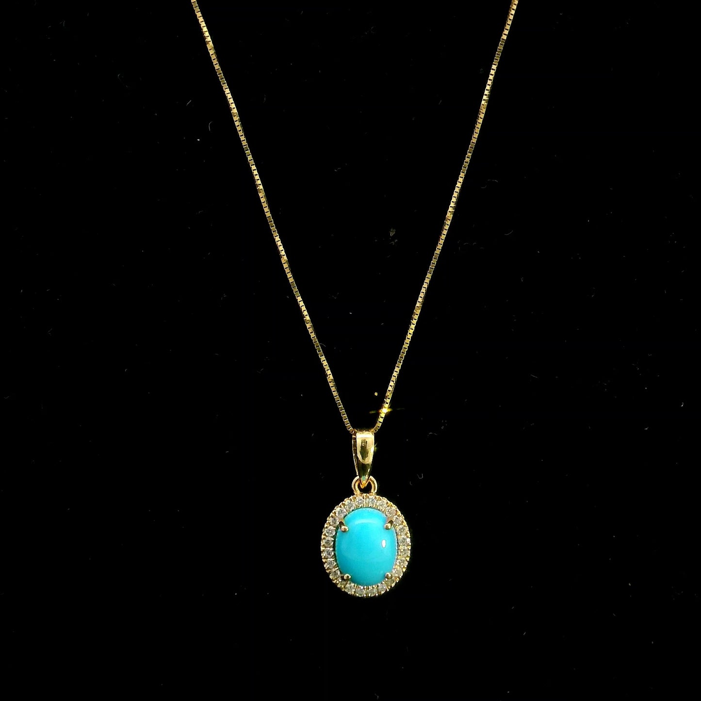 Natural turquoise diamond halo pendant in solid 18K yellow gold featuring a 1.22 carat oval turquoise surrounded by 0.12 carat natural diamonds.