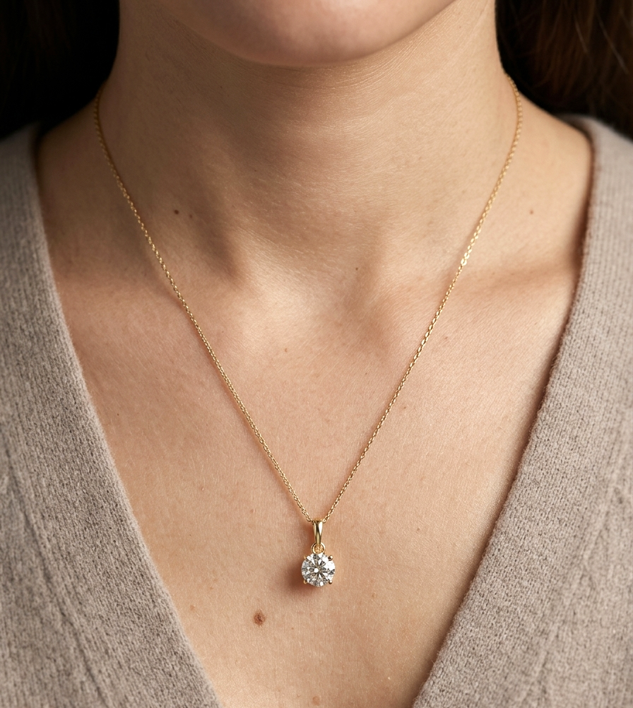 18K yellow gold solitaire pendant featuring a 0.70 carat GIA certified round brilliant natural diamond in a classic four-prong setting, supplied without a chain.