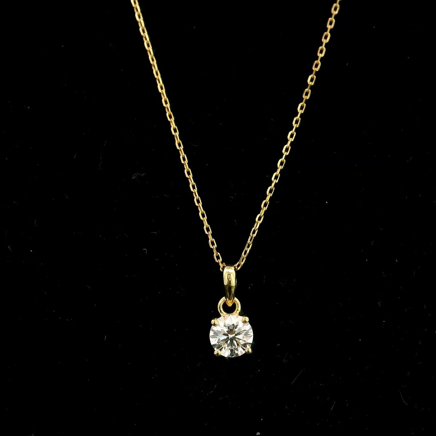 18K yellow gold solitaire pendant featuring a 0.70 carat GIA certified round brilliant natural diamond in a classic four-prong setting, supplied without a chain.