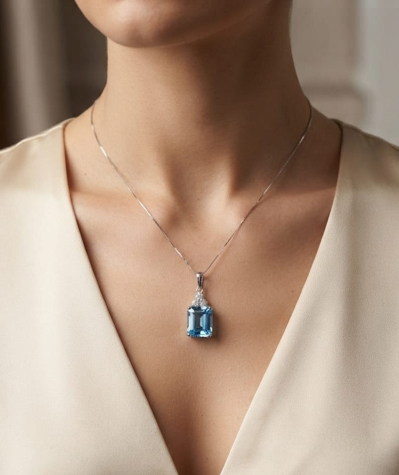 Swiss blue topaz pendant with emerald-cut blue topaz and diamond accents in 18K white gold.
