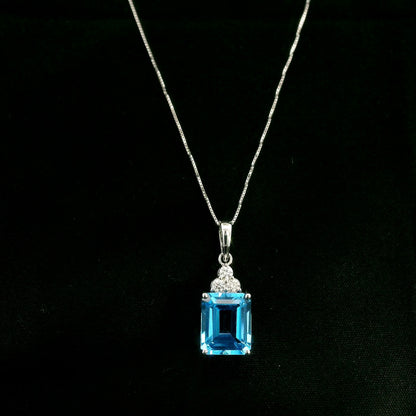 Swiss blue topaz pendant with emerald-cut blue topaz and diamond accents in 18K white gold.