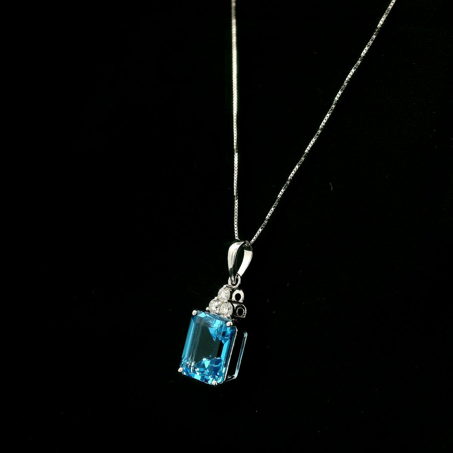 Swiss blue topaz pendant with emerald-cut blue topaz and diamond accents in 18K white gold.