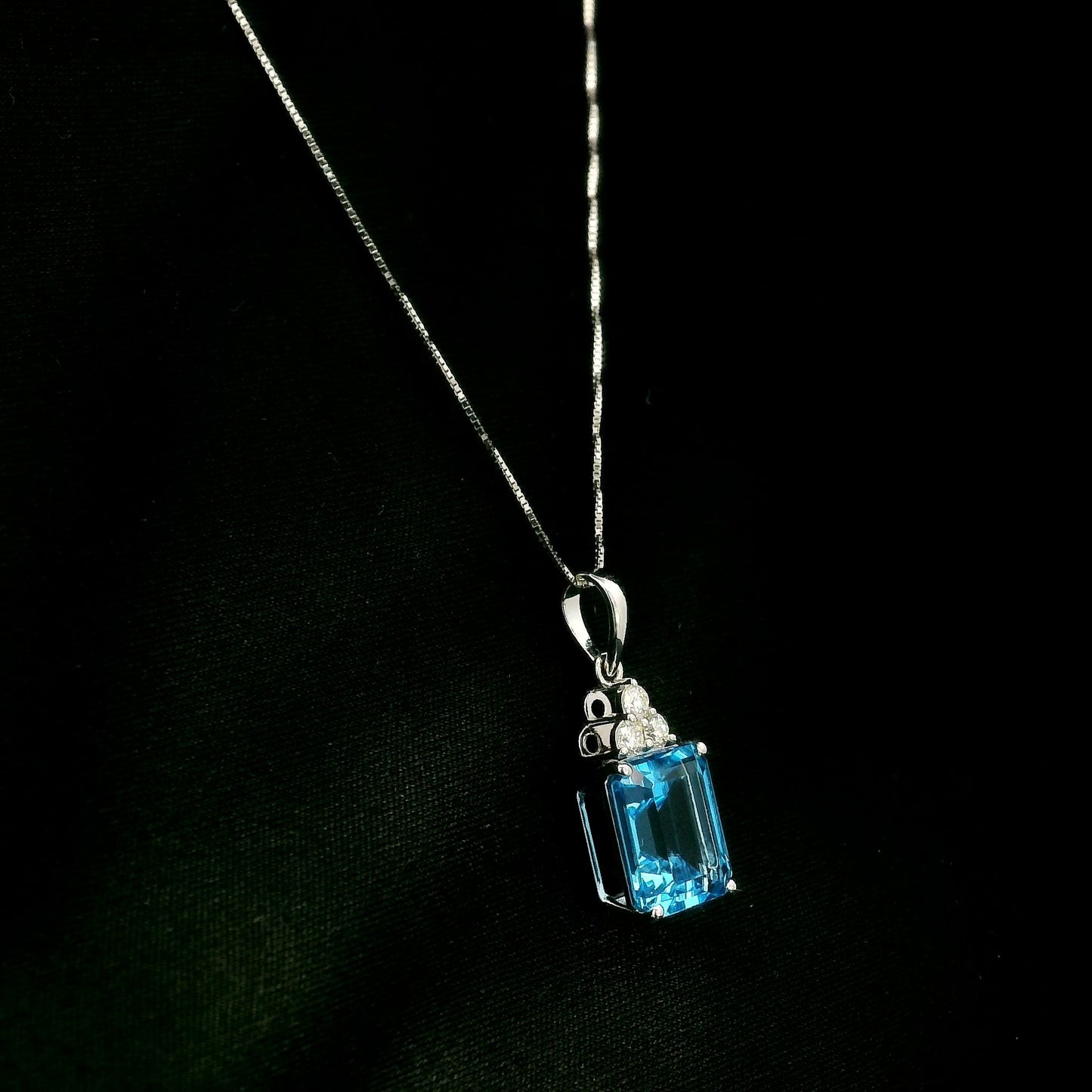 Swiss blue topaz pendant with emerald-cut blue topaz and diamond accents in 18K white gold.