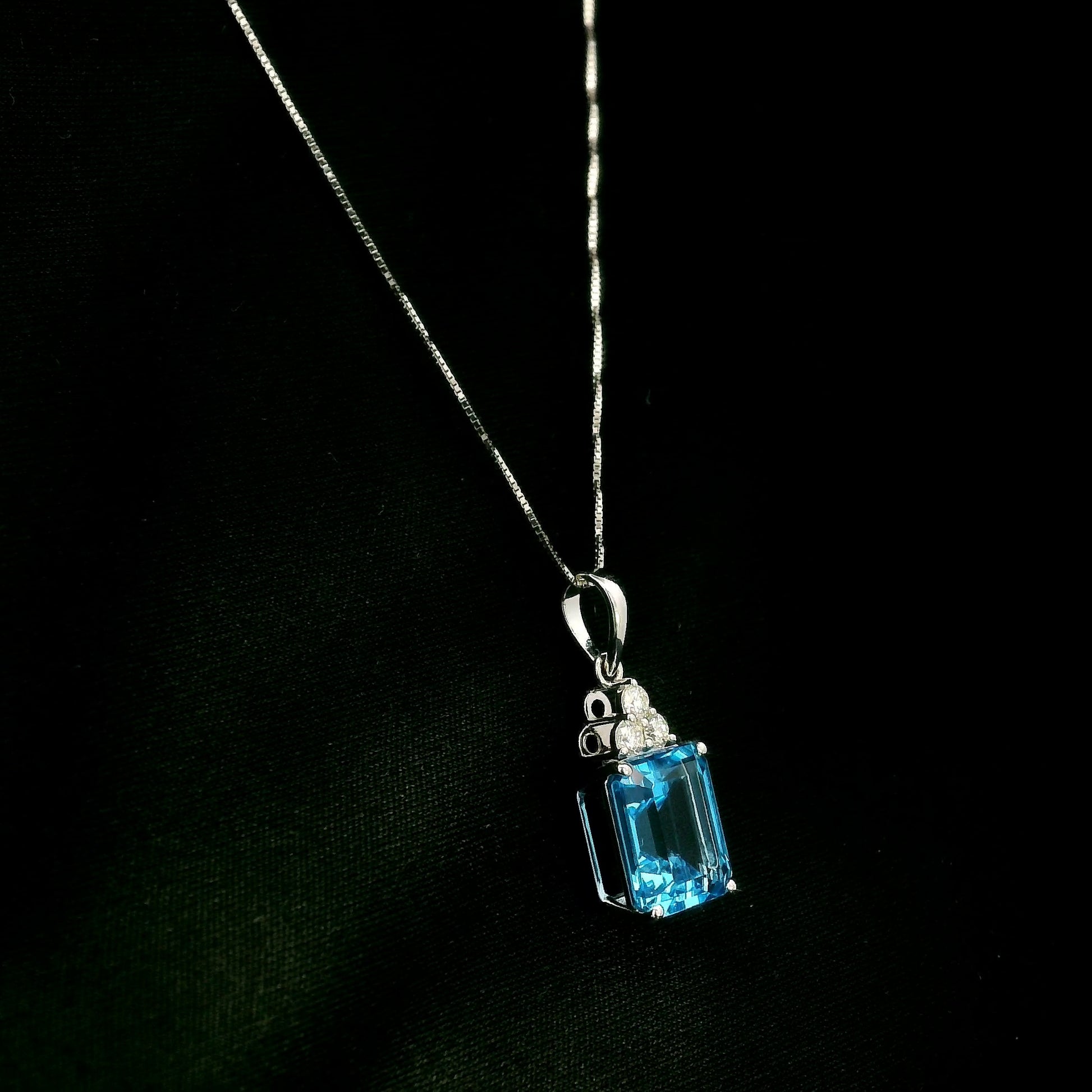Swiss blue topaz pendant with emerald-cut blue topaz and diamond accents in 18K white gold.