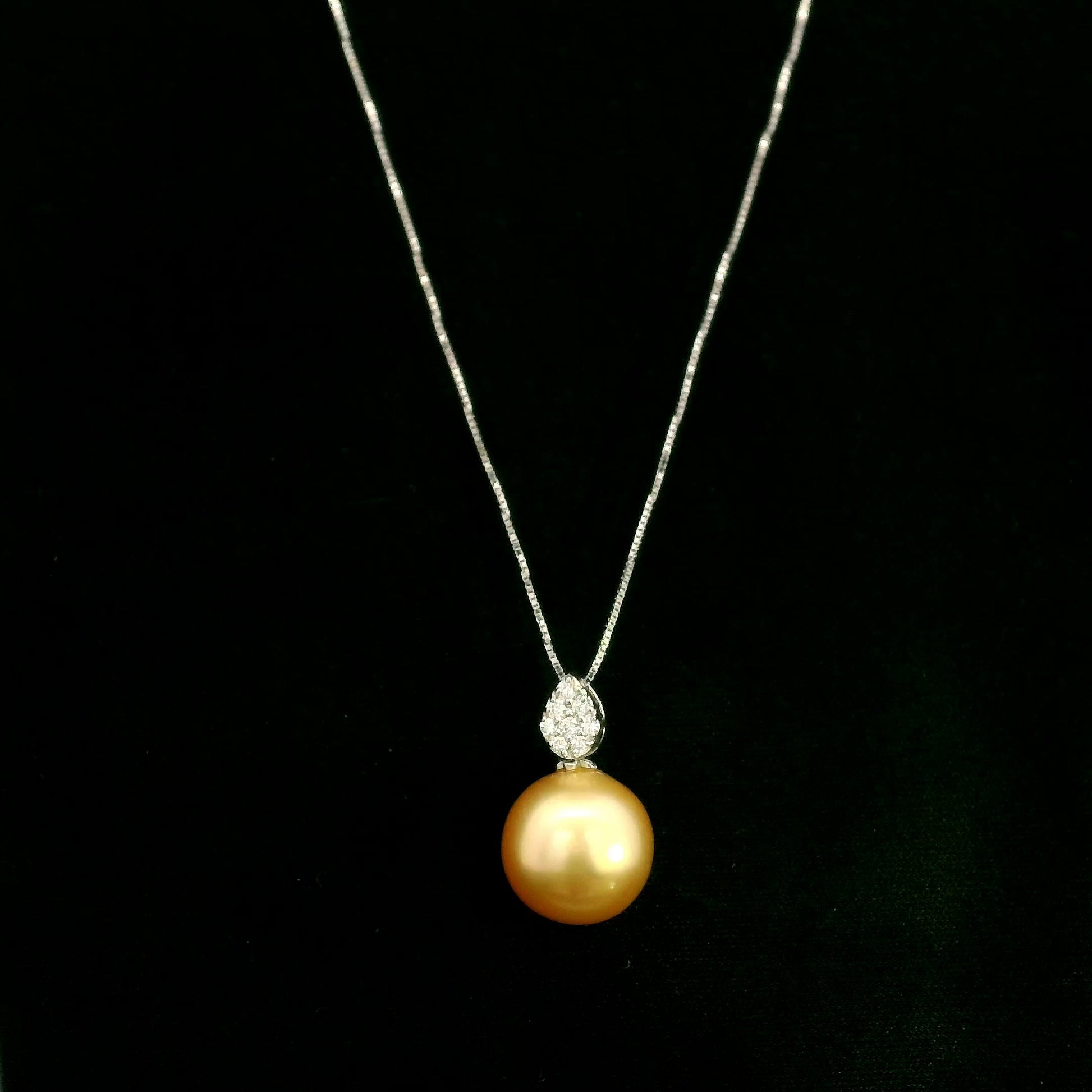 South Sea golden pearl and diamond pendant in 18K white gold featuring a 10 x 13 mm golden pearl and pear-shaped diamond detail.