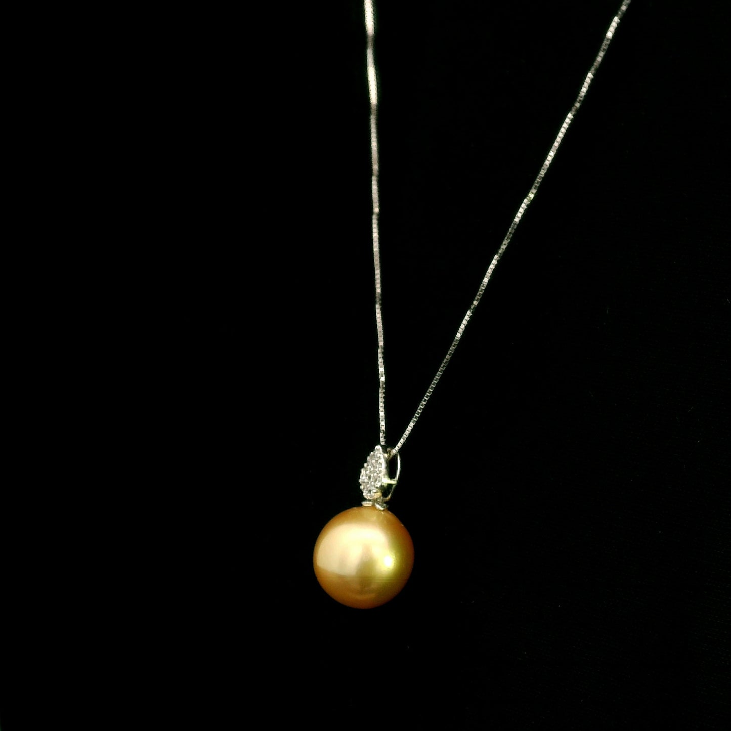 South Sea golden pearl and diamond pendant in 18K white gold featuring a 10 x 13 mm golden pearl and pear-shaped diamond detail.