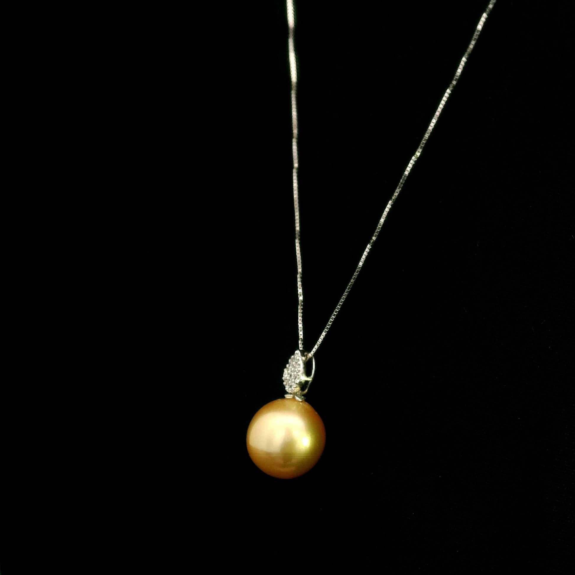 South Sea golden pearl and diamond pendant in 18K white gold featuring a 10 x 13 mm golden pearl and pear-shaped diamond detail.