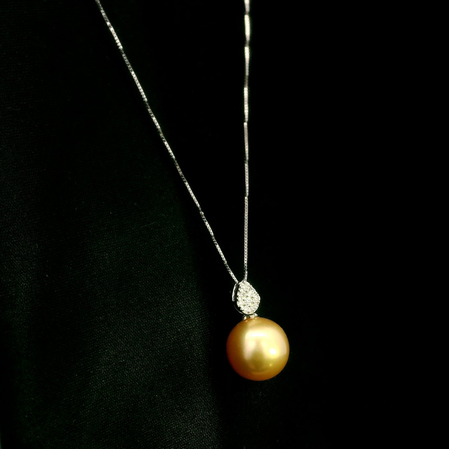 South Sea golden pearl and diamond pendant in 18K white gold featuring a 10 x 13 mm golden pearl and pear-shaped diamond detail.
